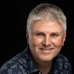 En mann som smiler til kameraet