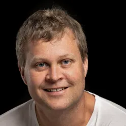 En mann som smiler til kameraet