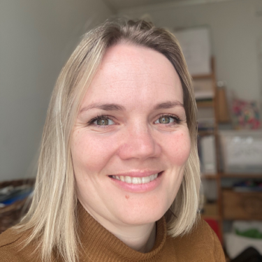 En kvinne som smiler til kameraet