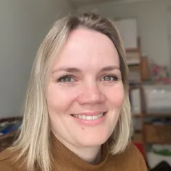 En kvinne som smiler til kameraet