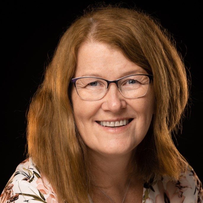 En kvinne med langt hår som smiler