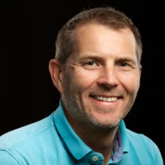 En mann som smiler til kameraet