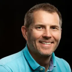 En mann som smiler til kameraet