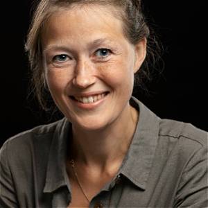 Et nærbilde av en smilende person