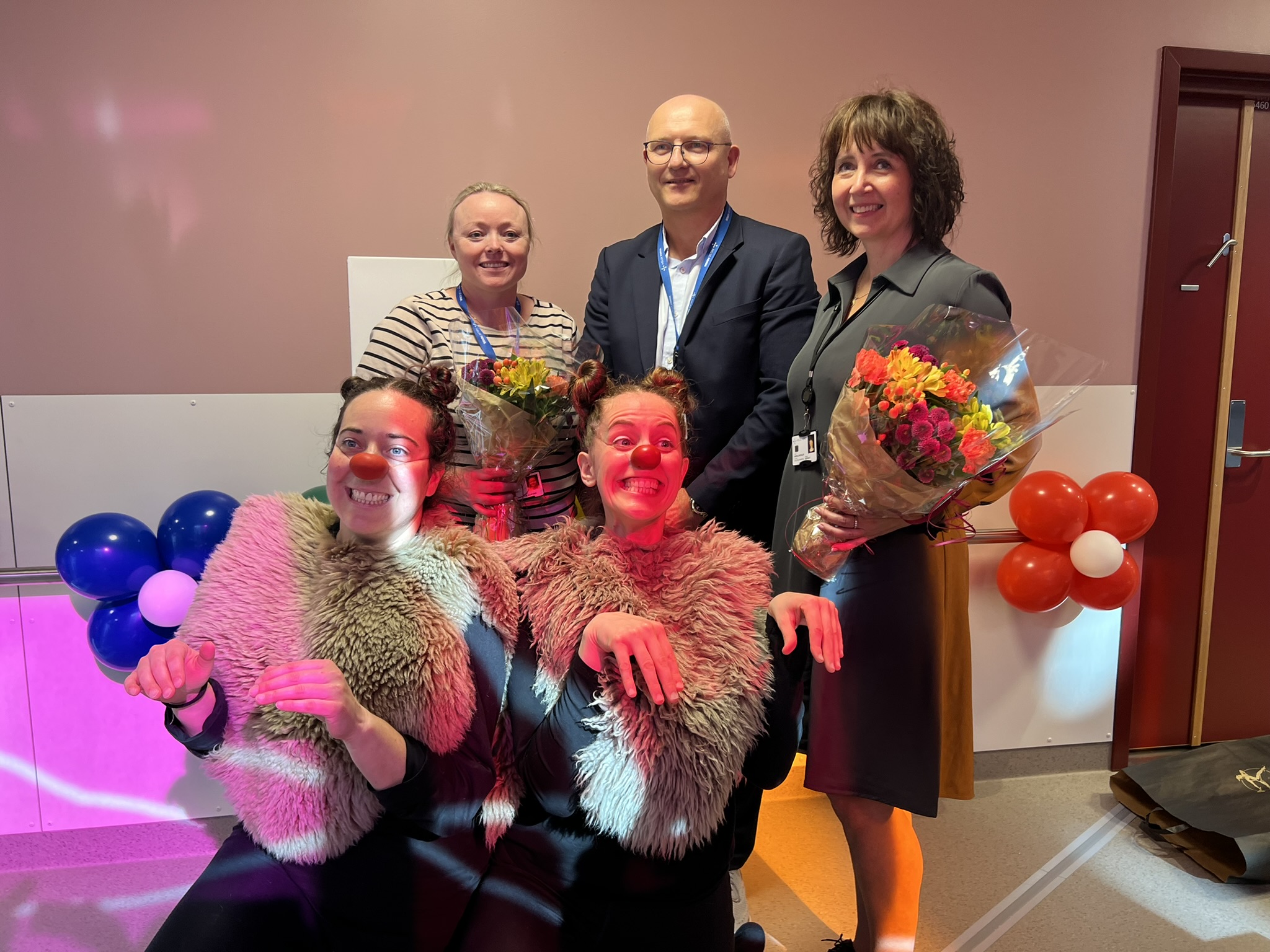 En gruppe mennesker som poserer for et bilde med ballonger