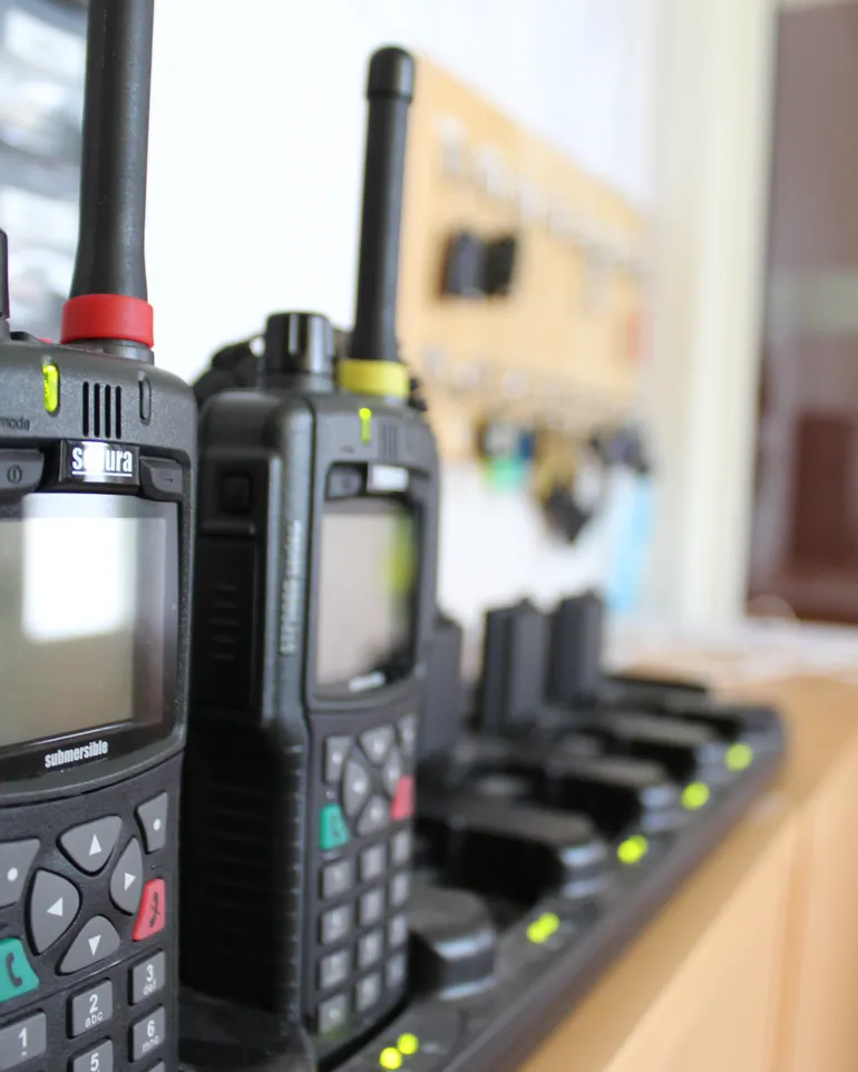 To naudtelefonar som står i ladarar på eit kontor ved AMK-sentralen