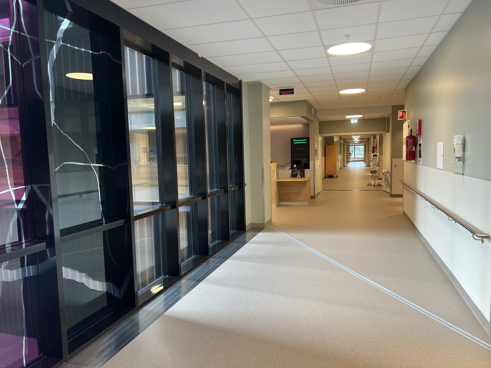 Ein lang sjukehusgang med glassdører