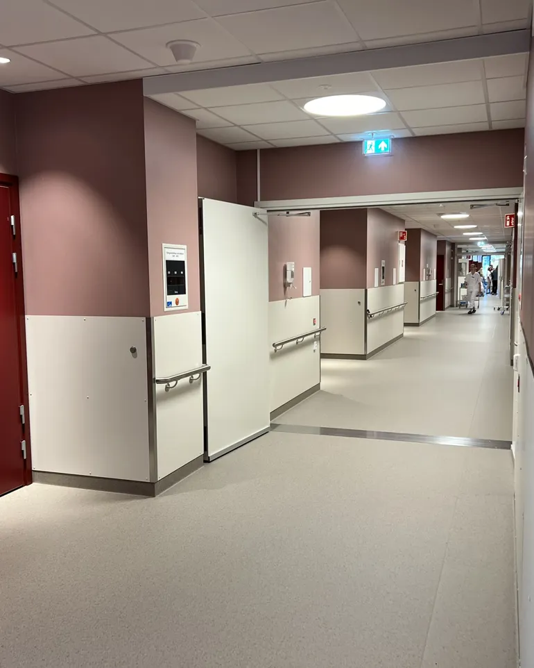 Ein lang gang med raude dører