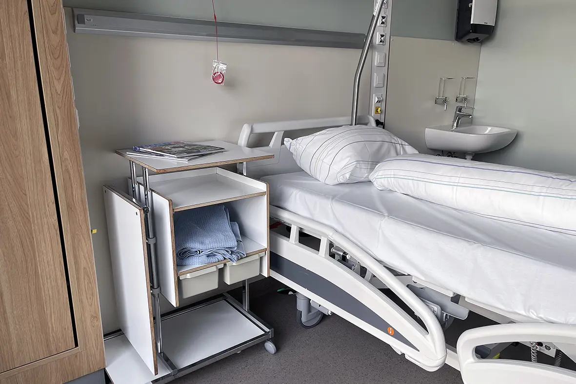 Et sykehusrom med seng og vask
