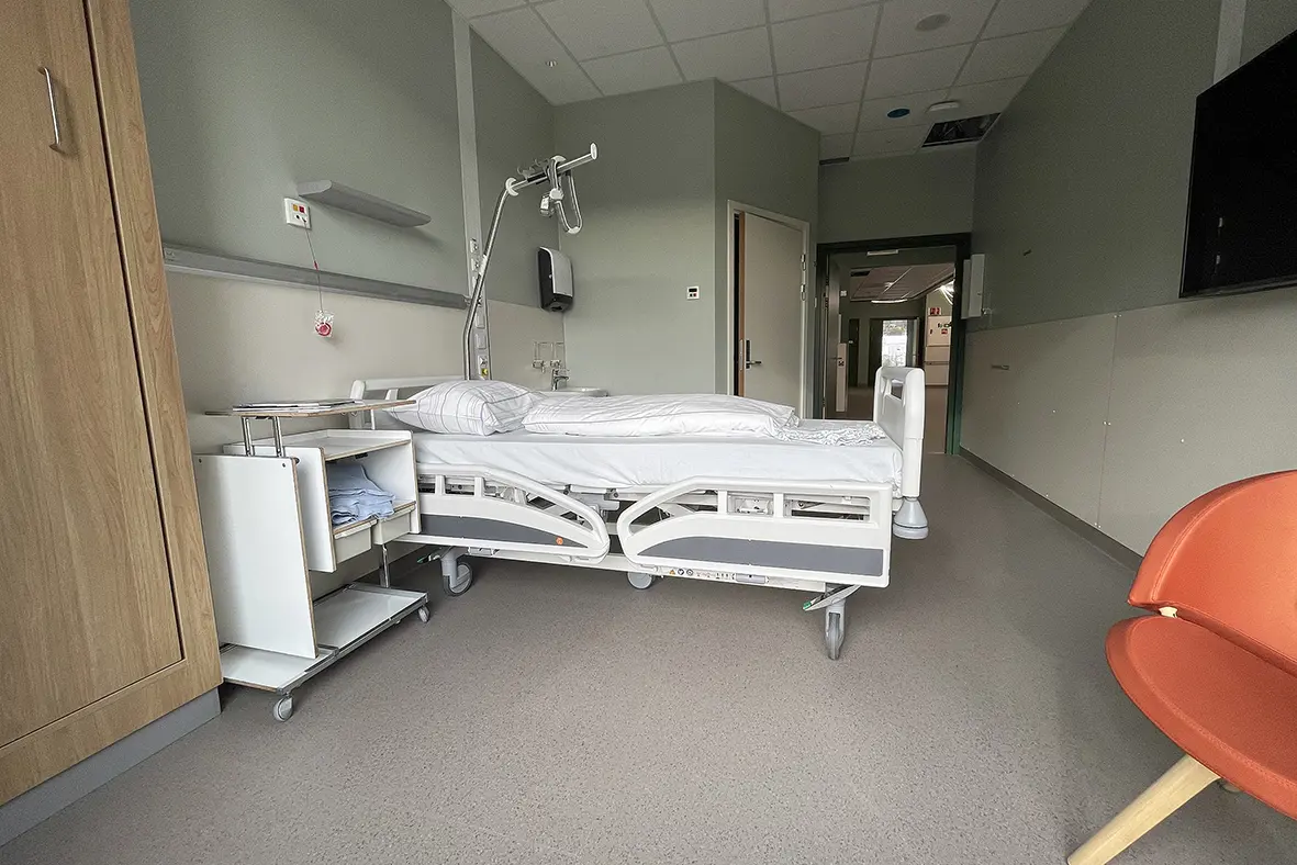 Et sykehusrom med en seng og en stol