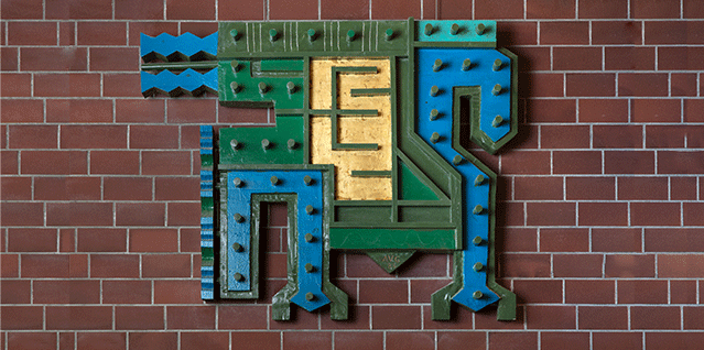 Murvegg med eit kunstverk i blått, grønt og gult