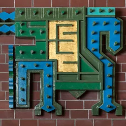 Murvegg med eit kunstverk i blått, grønt og gult