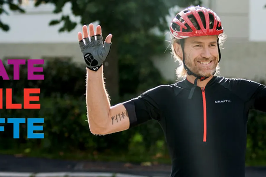 Syklist med hendene opp.