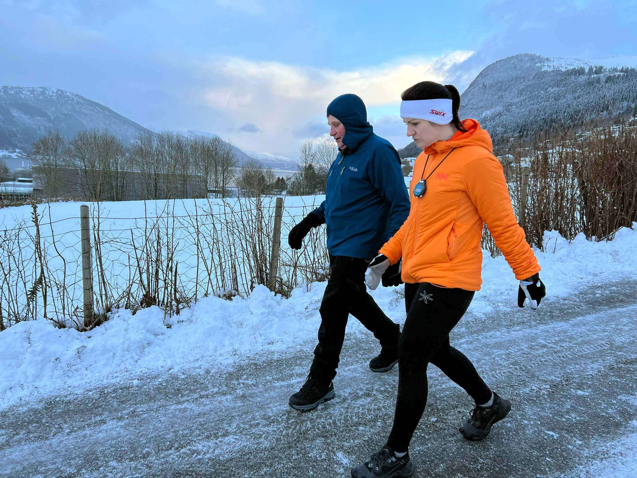 ein mann og ei kvinne går tur utandørs på vinterføre