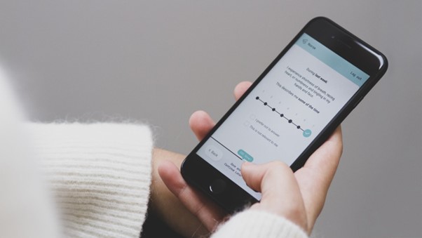 Ein person som held ein telefon med eit utfyllingsskjema