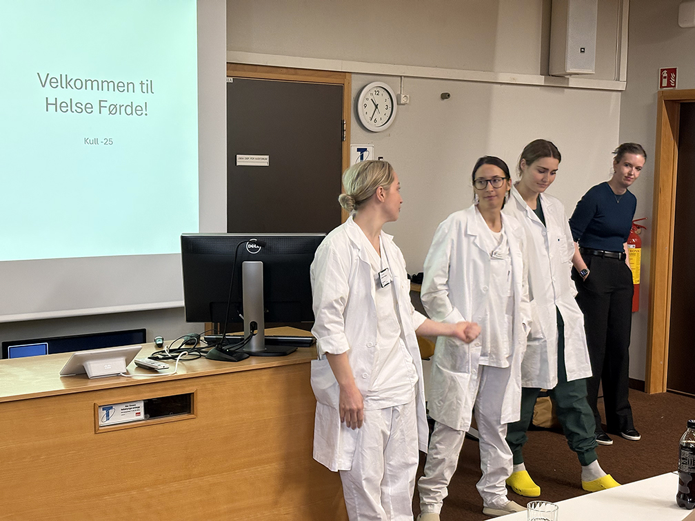 Ei gruppe menneske som står framfor ein skjerm