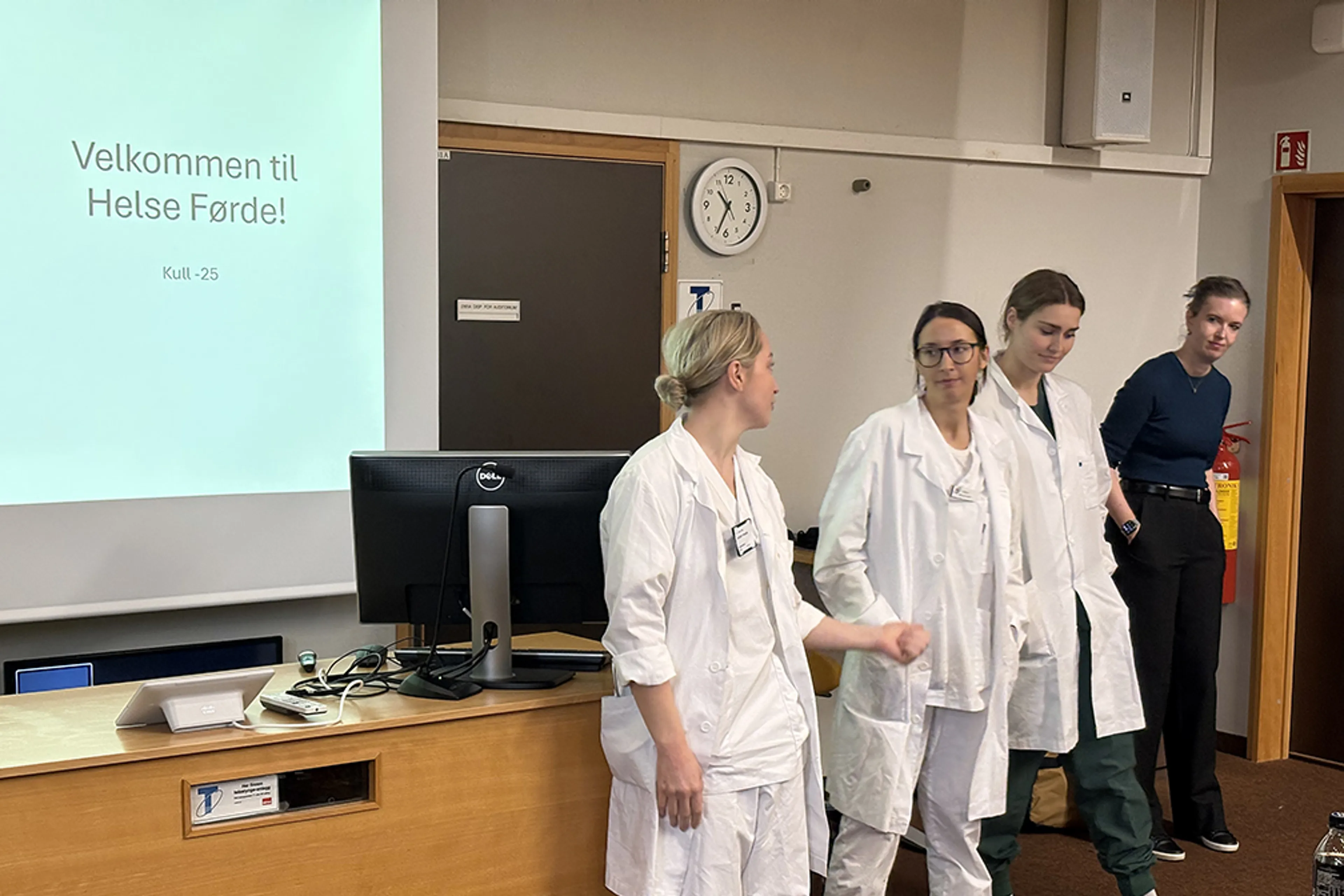 Ei gruppe menneske som står framfor ein skjerm