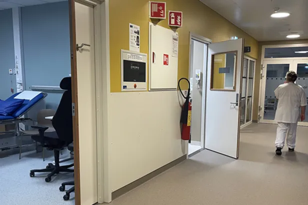 Ein person som går i ein sjukehuskorridor
