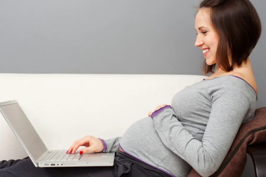 gravid kvinne med laptop