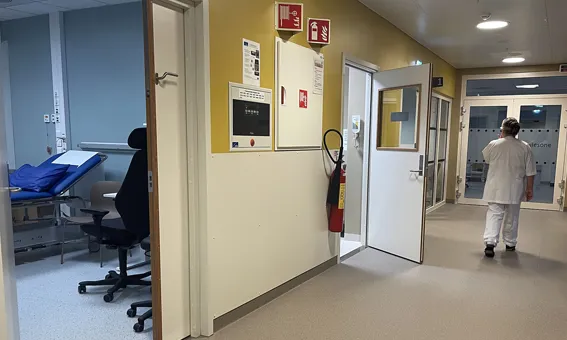 Ein person som går gjennom ein sjukehuskorridor