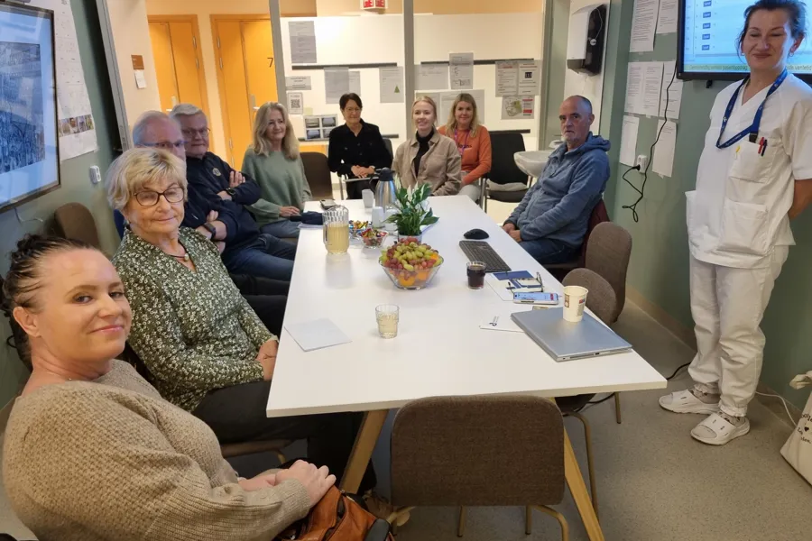 Ei gruppe folk samla rundt eit møtebord