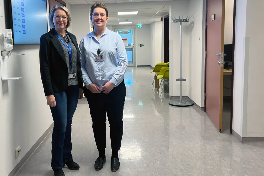 To kvinner som står i ein korridor på eit sjukehus