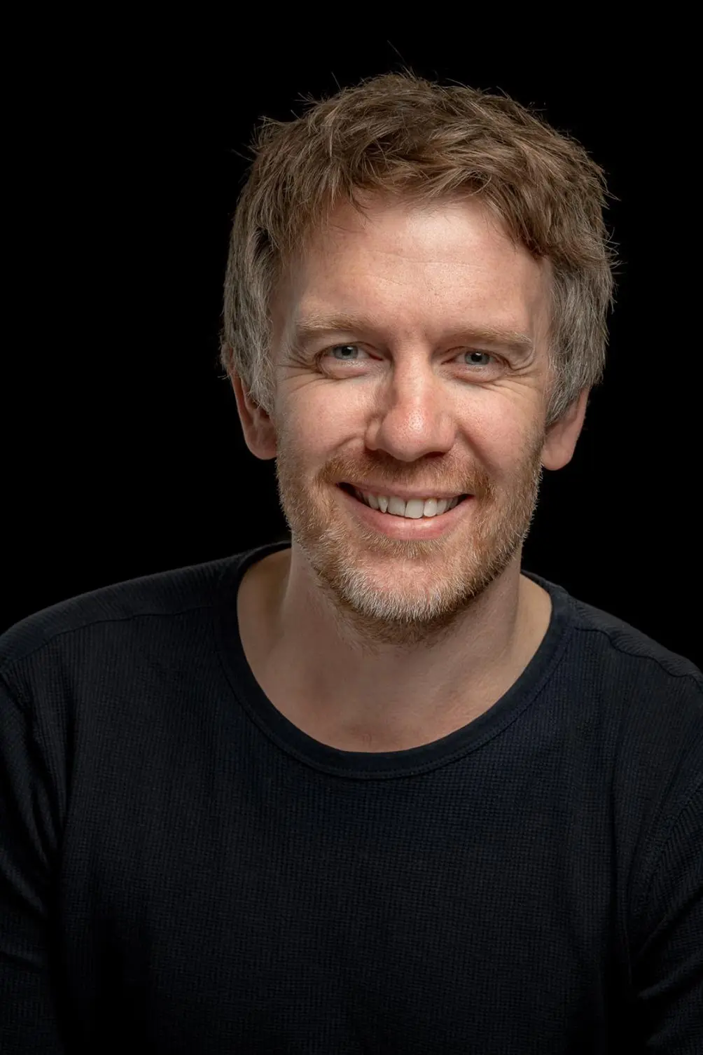 En mann som smiler til kameraet