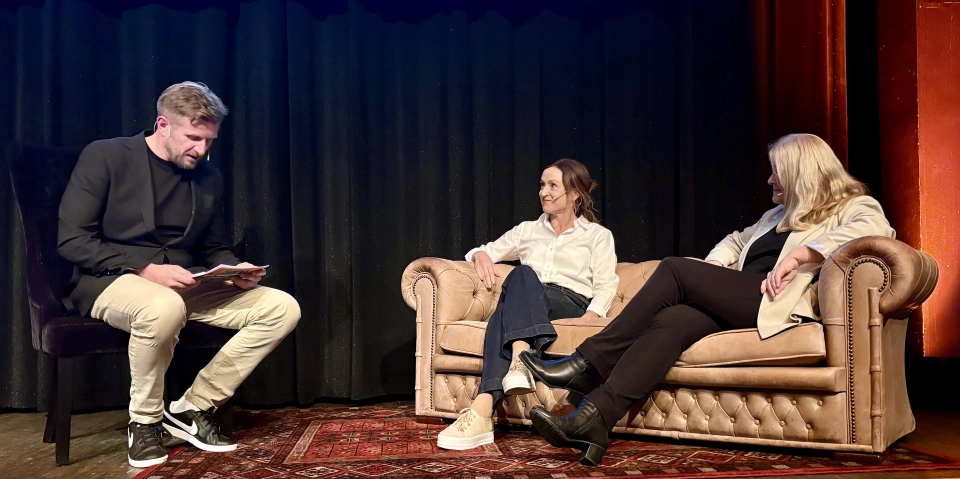 En gruppe mennesker som sitter i en sofa