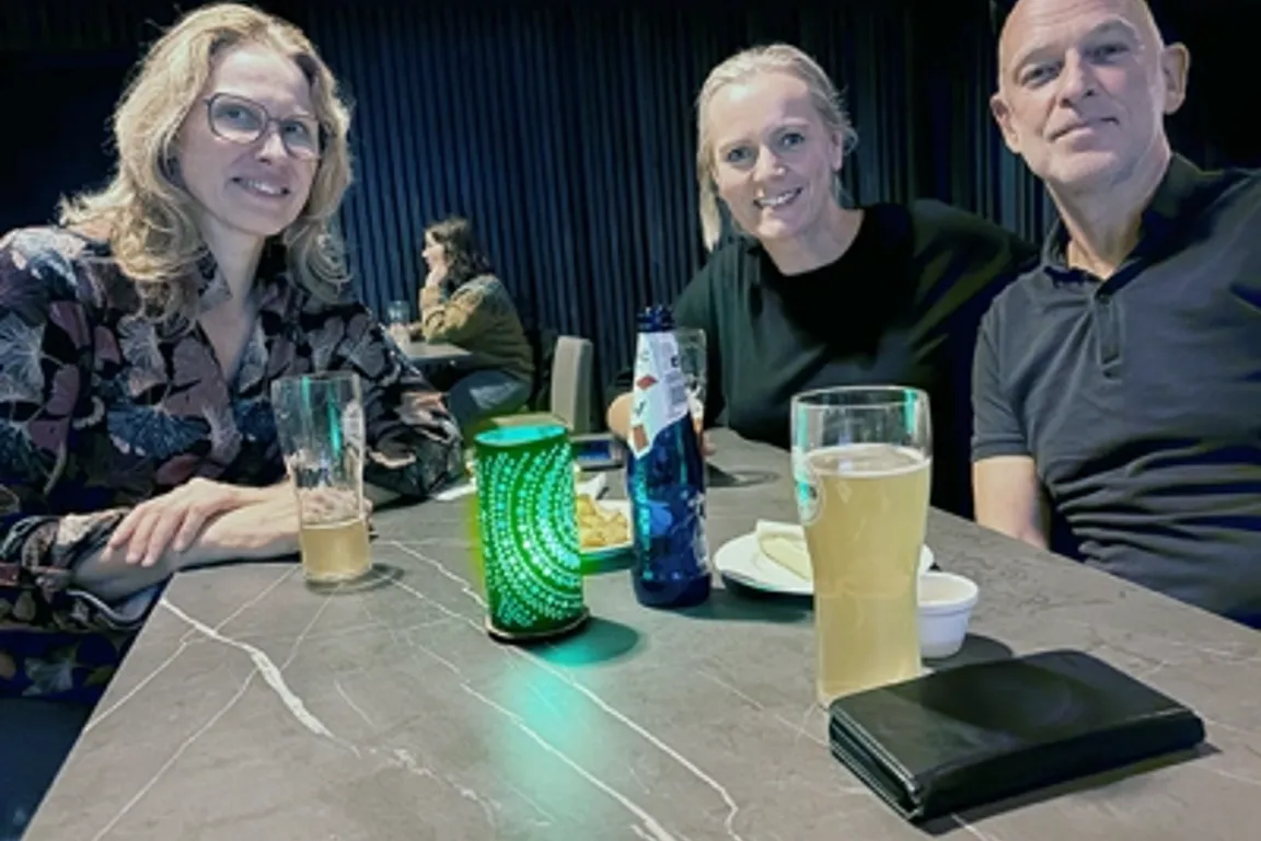 En gruppe mennesker som sitter ved et bord med drikke