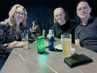 En gruppe mennesker som sitter ved et bord med drikke